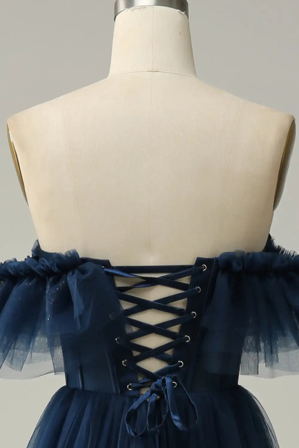Navy blue dress with lace-up back on a mannequin against a neutral background