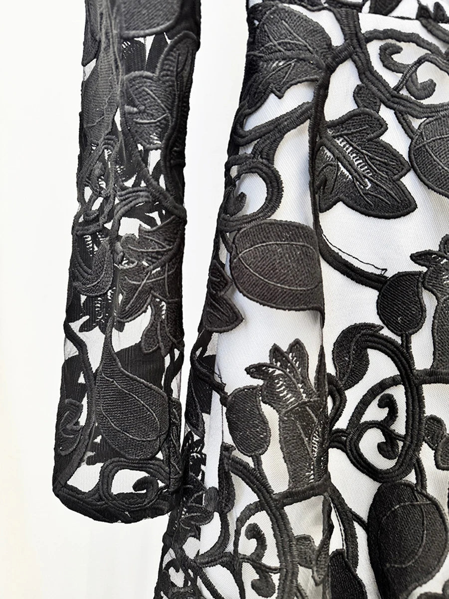 Close-up of black floral lace fabric on a white background