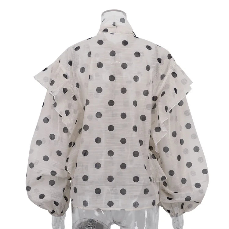 White blouse with black polka dots on a mannequin against a white background