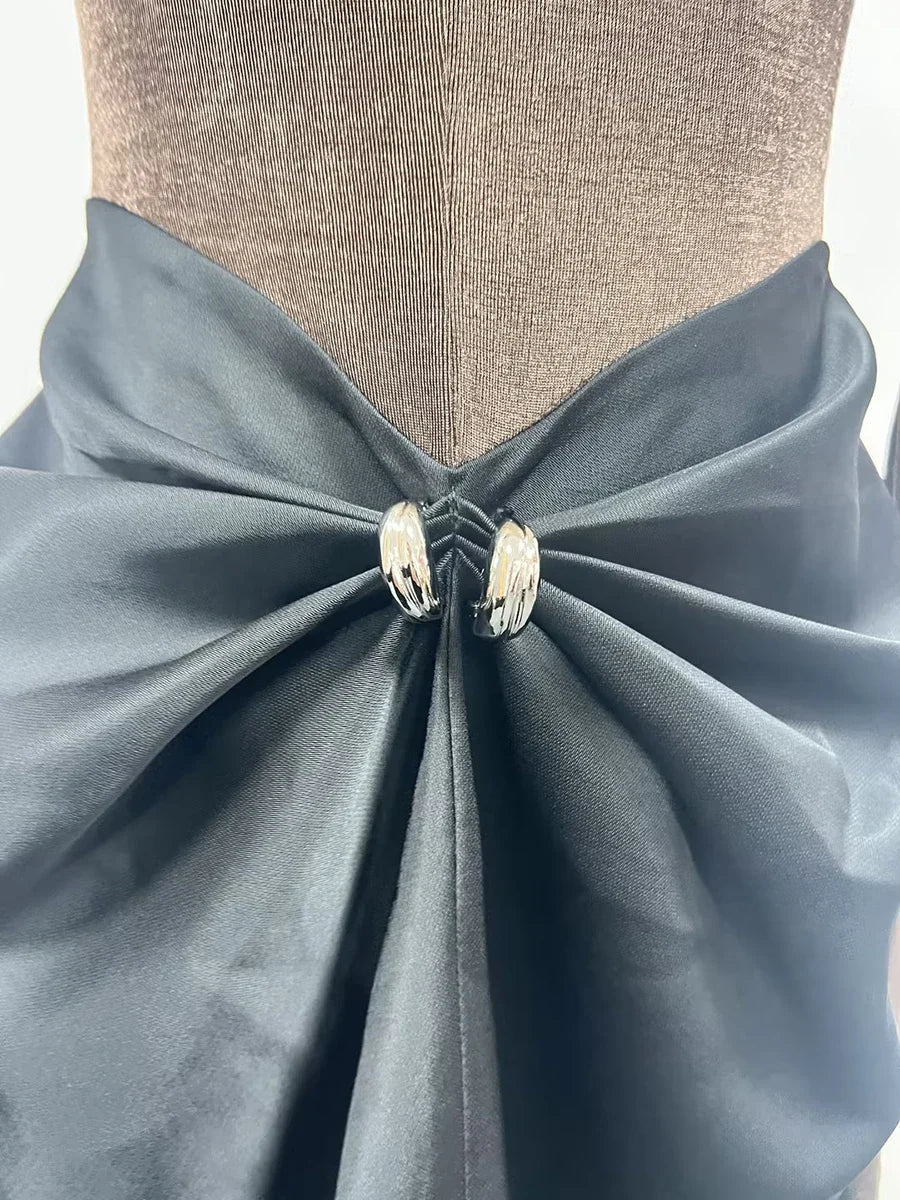 Mannequin wearing a light blue fabric bow with decorative elements on a neutral background