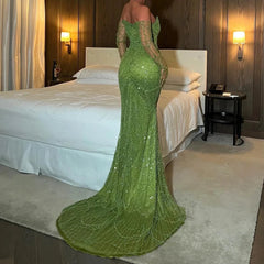  A model wearing the green mermaid evening gown with gloves, showcasing its flattering silhouette and flowing train.  Golden Atelier 2