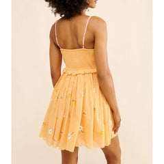 Woman wearing a yellow dress with floral patterns on a beige background