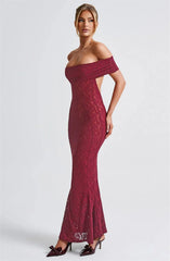 Woman wearing a burgundy off-shoulder lace dress on a white background