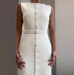 White dress with button details on a plain background