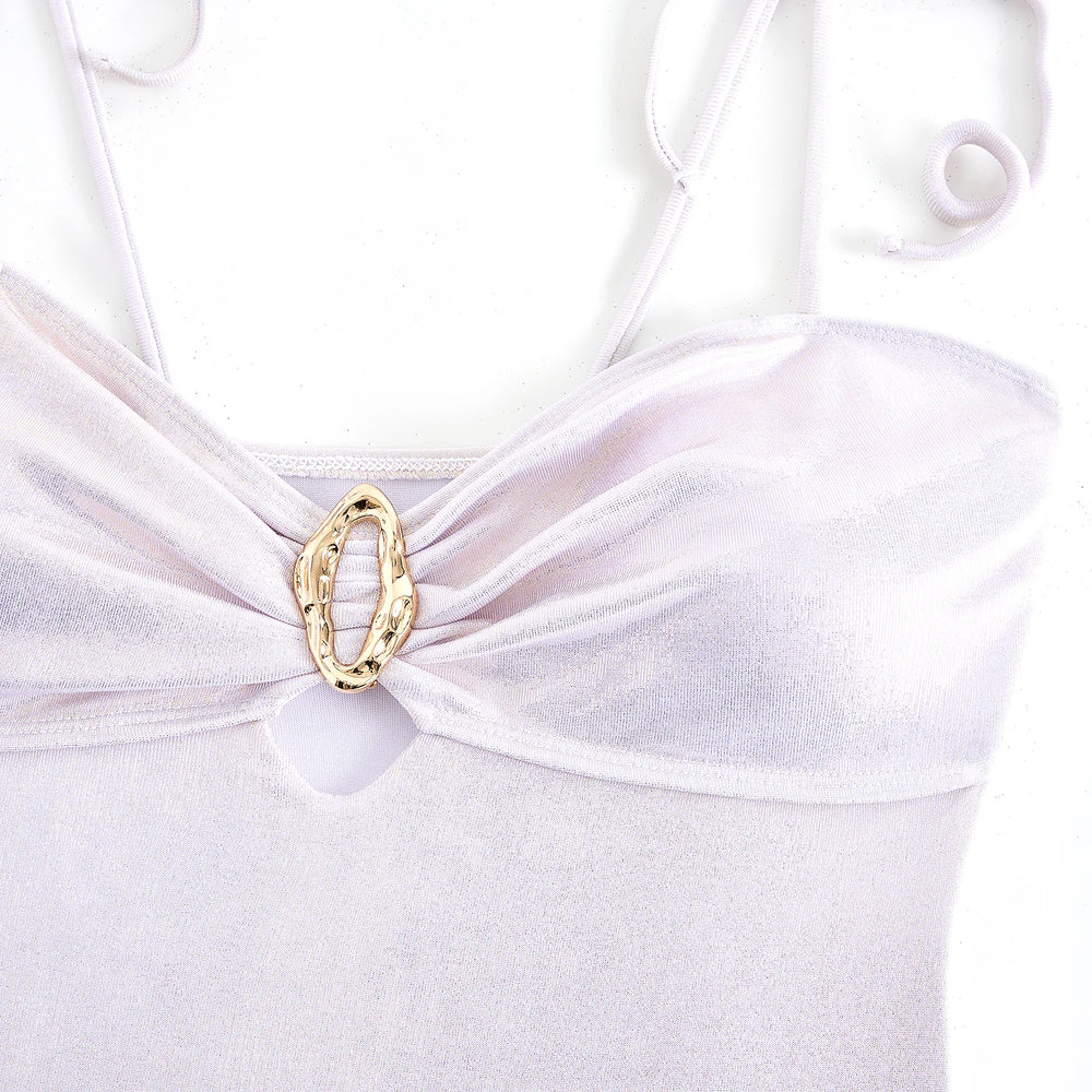Close-up of the gold decorative accent on the bust of a white metallic bikini top.