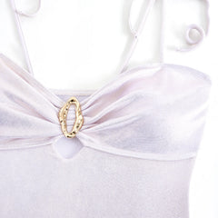Close-up of the gold decorative accent on the bust of a white metallic bikini top.