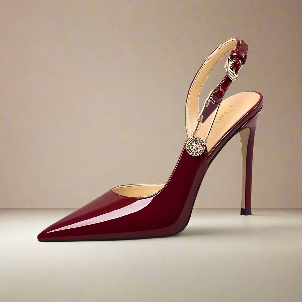 Red high-heeled shoe with a decorative strap on a light gray background