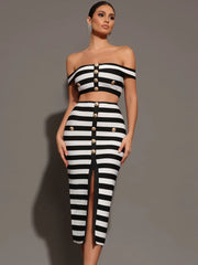Woman wearing a black and white striped outfit with button details on a gray background