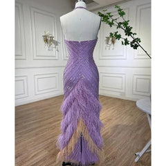 Purple evening gown with feather details on a mannequin against a white wall.
