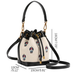 Bear print bucket bag with black faux leather trim and gold hardware, showing dimensions.