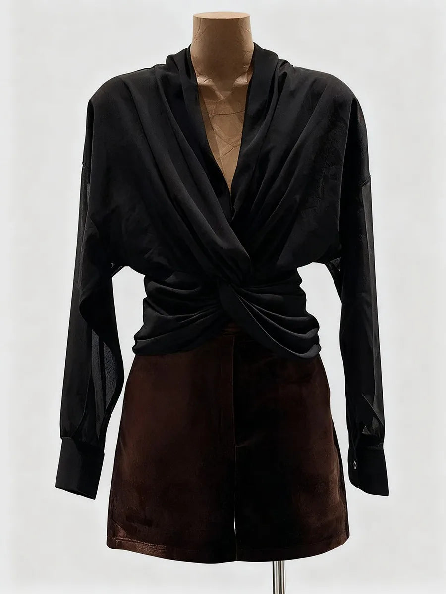 Black long-sleeve top and brown skirt on a mannequin against a white background