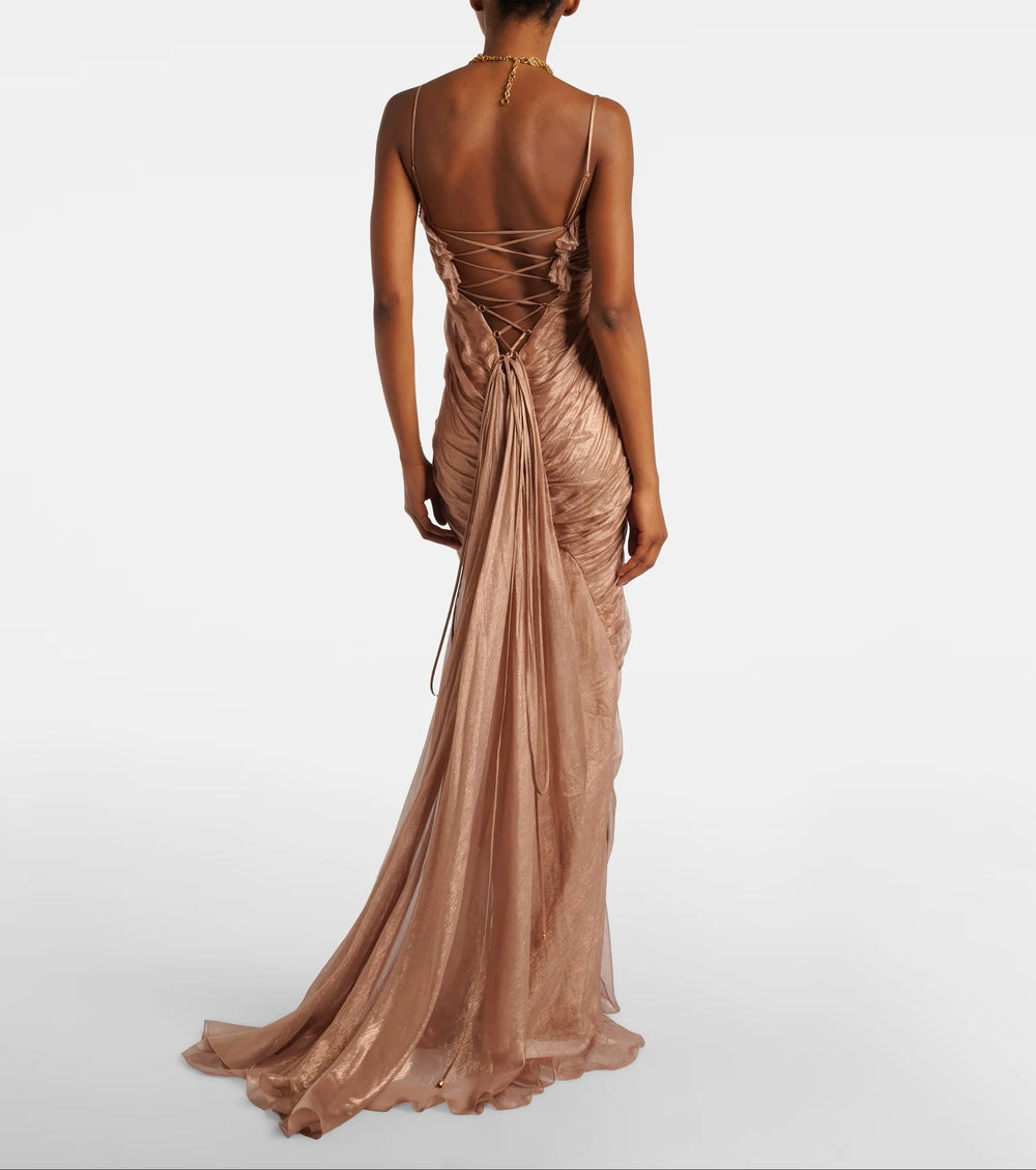 Back view of a floor-length ruched spaghetti strap evening gown with lace-up detail.