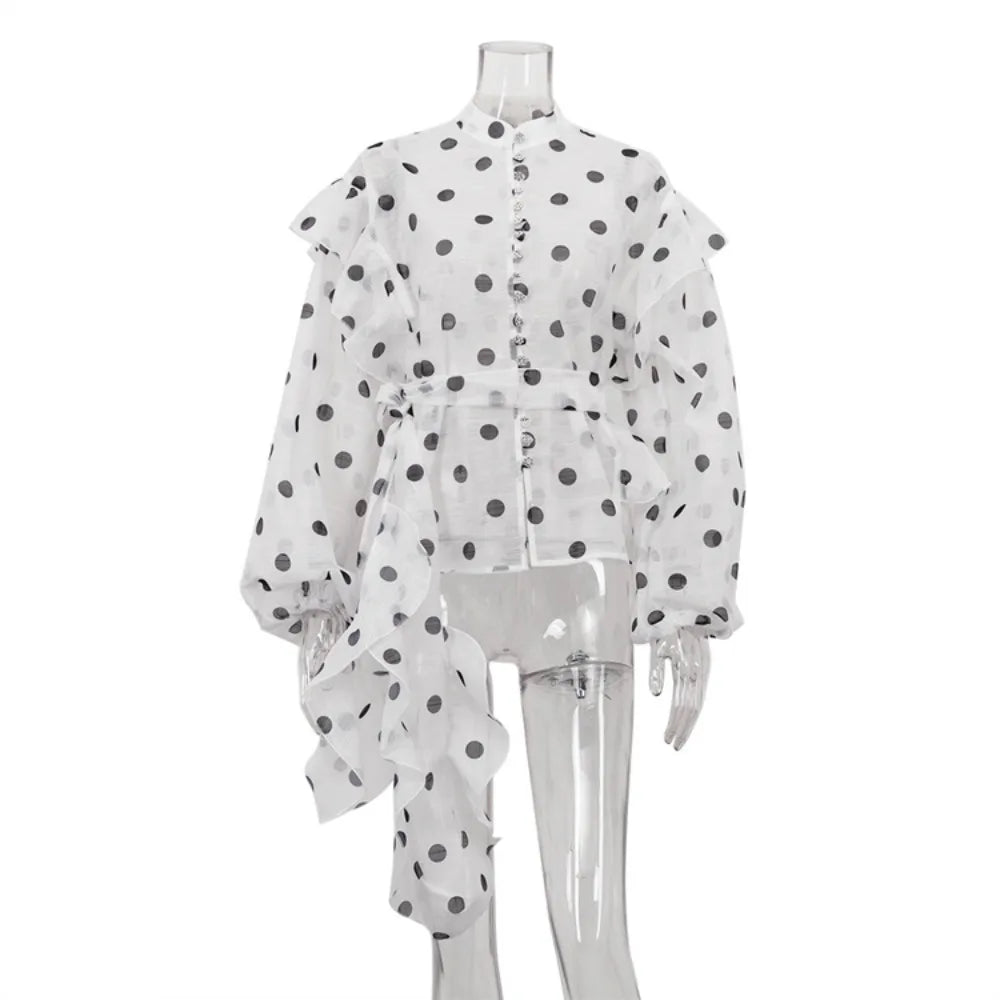 White sheer blouse with black polka dots on a mannequin against a white background