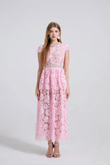 Woman wearing a pink lace dress with a white background