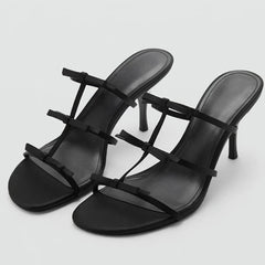 Black stiletto heels with delicate bow straps.
