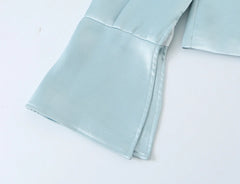 Close-up of the split cuff detail on a light blue satin blazer