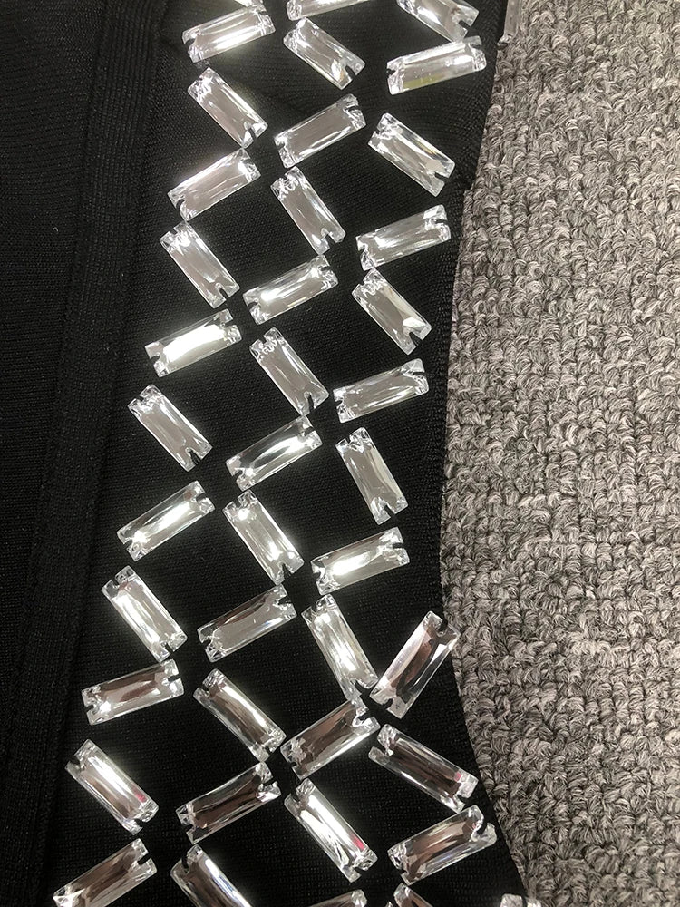 Close-up of a black shoe with silver embellishments on a textured gray surface