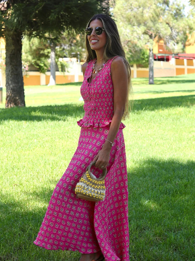 Woman in a pink dress standing on grass with trees in the background