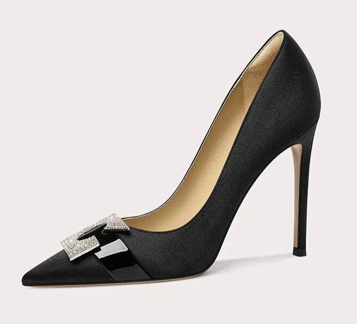 Black high-heeled shoe with a decorative bow on a light gray background