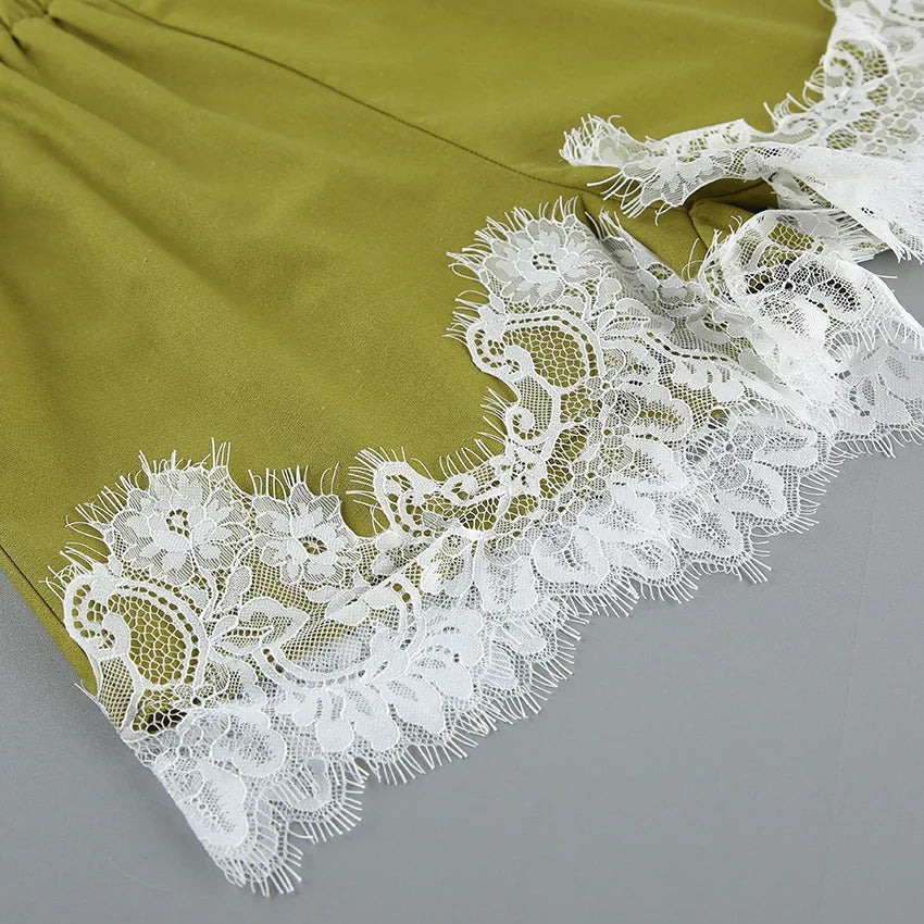 Close-up of white lace trim on a green fabric background