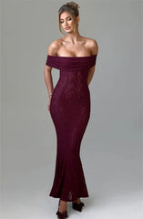Woman wearing a burgundy off-shoulder dress on a gray background