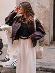 A woman wearing a stylish vintage leather jacket with a lapel collar and zipper closure. Golden Atelier 3