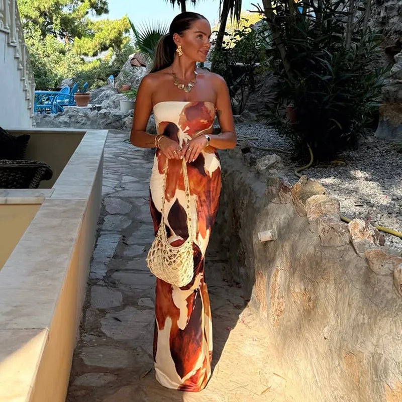 Woman in a strapless dress with a patterned design standing outdoors.