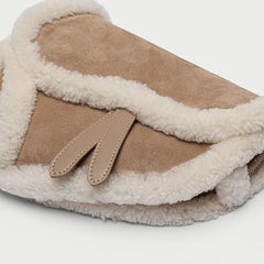 Close-up of shearling trim and flap detail on saddle bag