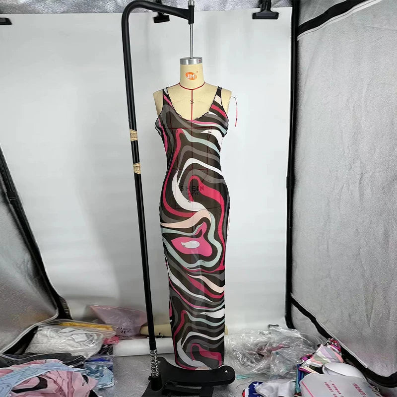 Mannequin wearing a patterned dress in a studio setting with lighting equipment.