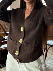 Brown ribbed cardigan with gold buttons worn by a person indoors.