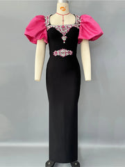 Black evening gown with pink sleeves on a mannequin against a gray background