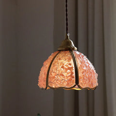 Pendant light with a textured glass shade against a neutral background
