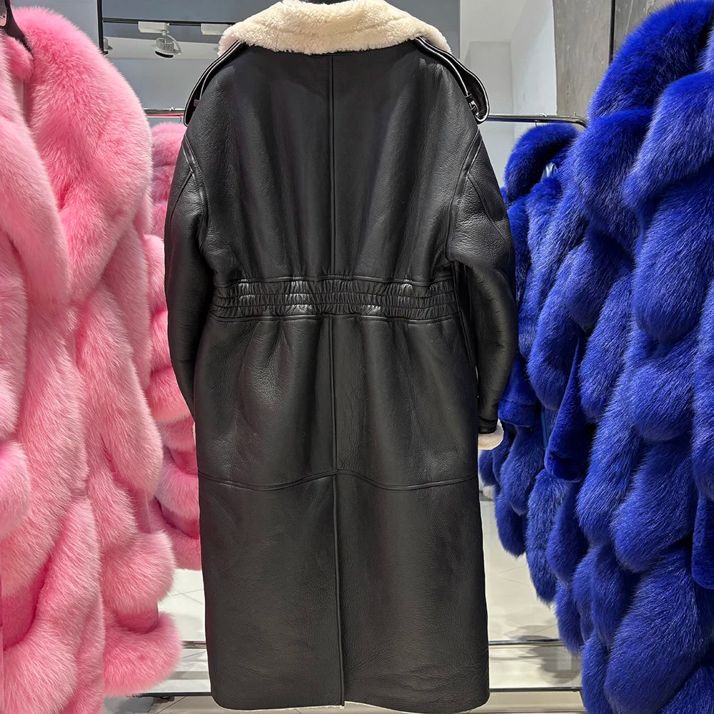 Black leather coat with fur lining displayed against colorful furs in a store setting.