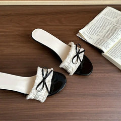 Close-up of bow detail on heeled slide sandal