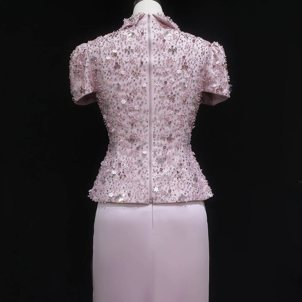 Short-sleeve sequined top on a mannequin against a black background