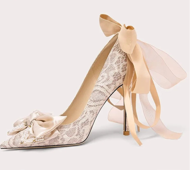 High-heeled shoe with lace design and ribbon on a light background