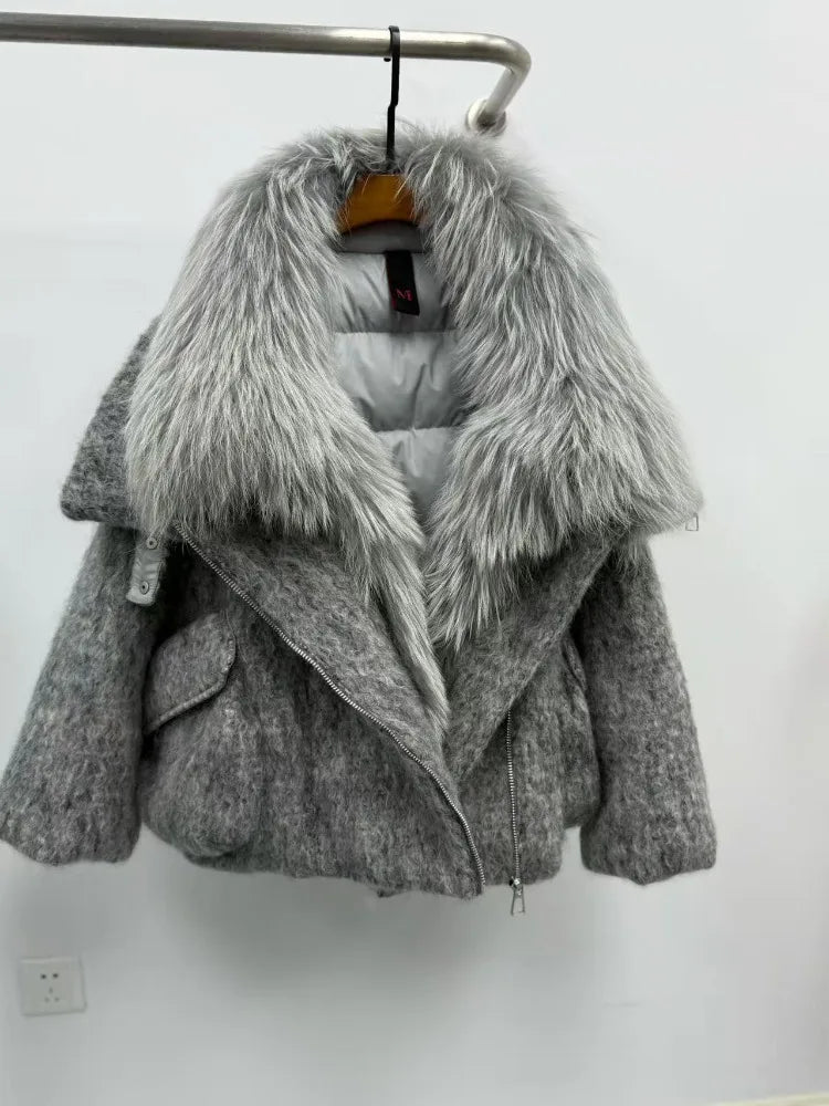 Gray coat with fur collar on a hanger against a white wall