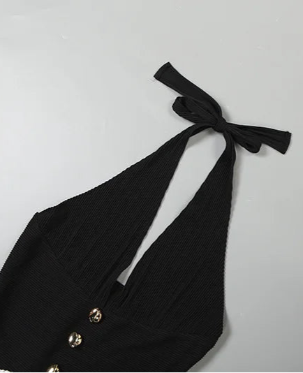 Black halter top with bow detail on a light gray background