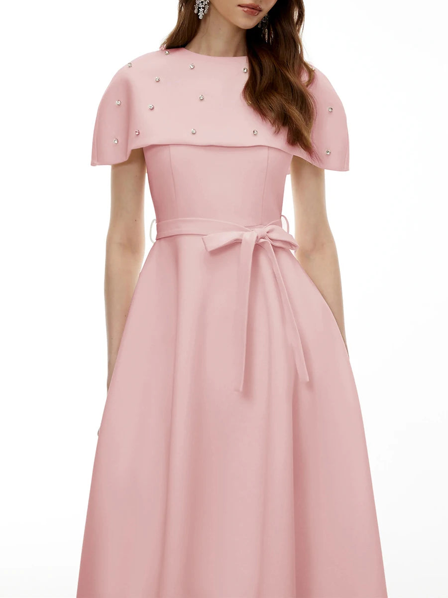 Model wearing a pink midi dress with a cape overlay