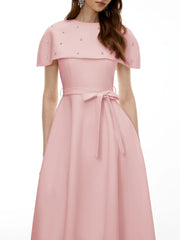 Model wearing a pink midi dress with a cape overlay