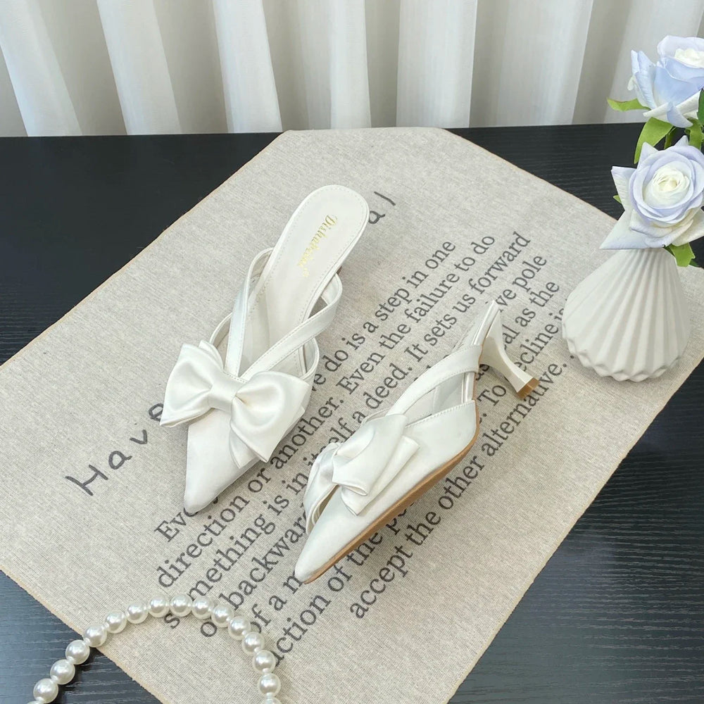 White bow shoes on a textured surface with text and decorative elements.