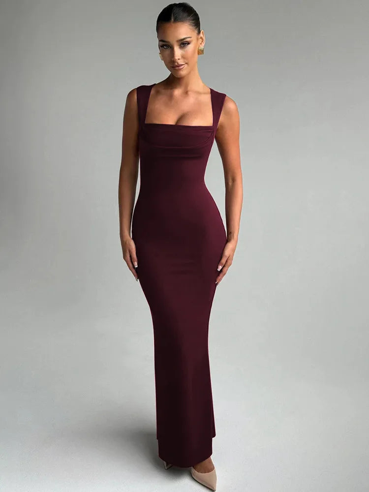 Woman wearing a burgundy evening gown against a gray background