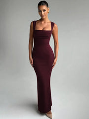 Woman wearing a burgundy evening gown against a gray background