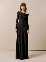 Woman wearing a black off-shoulder long-sleeve gown against a beige background