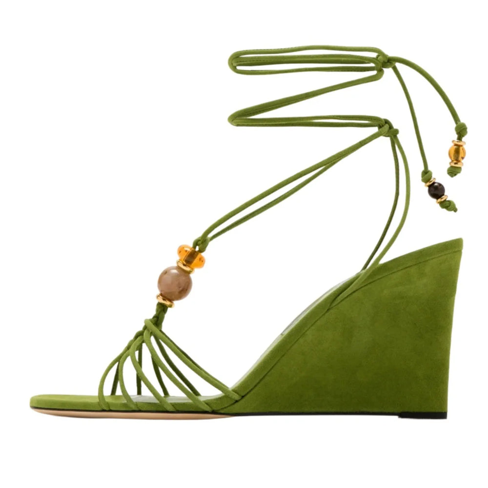 Side view of green suede strappy wedge sandals with natural stone beads