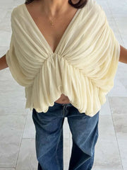 Front view of a ruched batwing sleeve blouse on a model