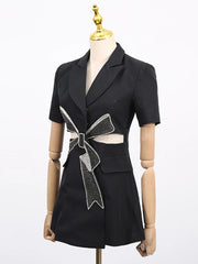 Black dress with a large bow detail on a mannequin against a white background