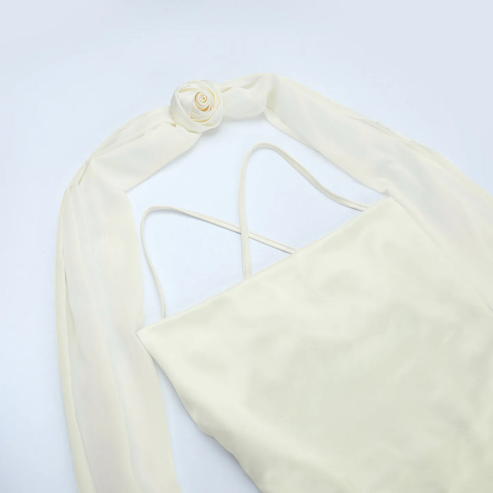 Cream-colored bikini top with thin straps on a light gray background
