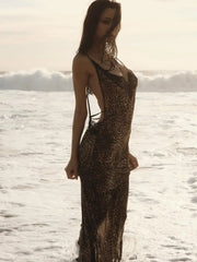Woman in a leopard print maxi dress at the beach