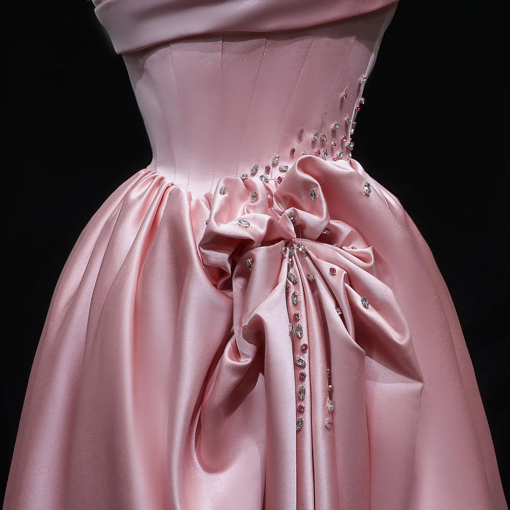 Pink evening gown with embellishments on a black background